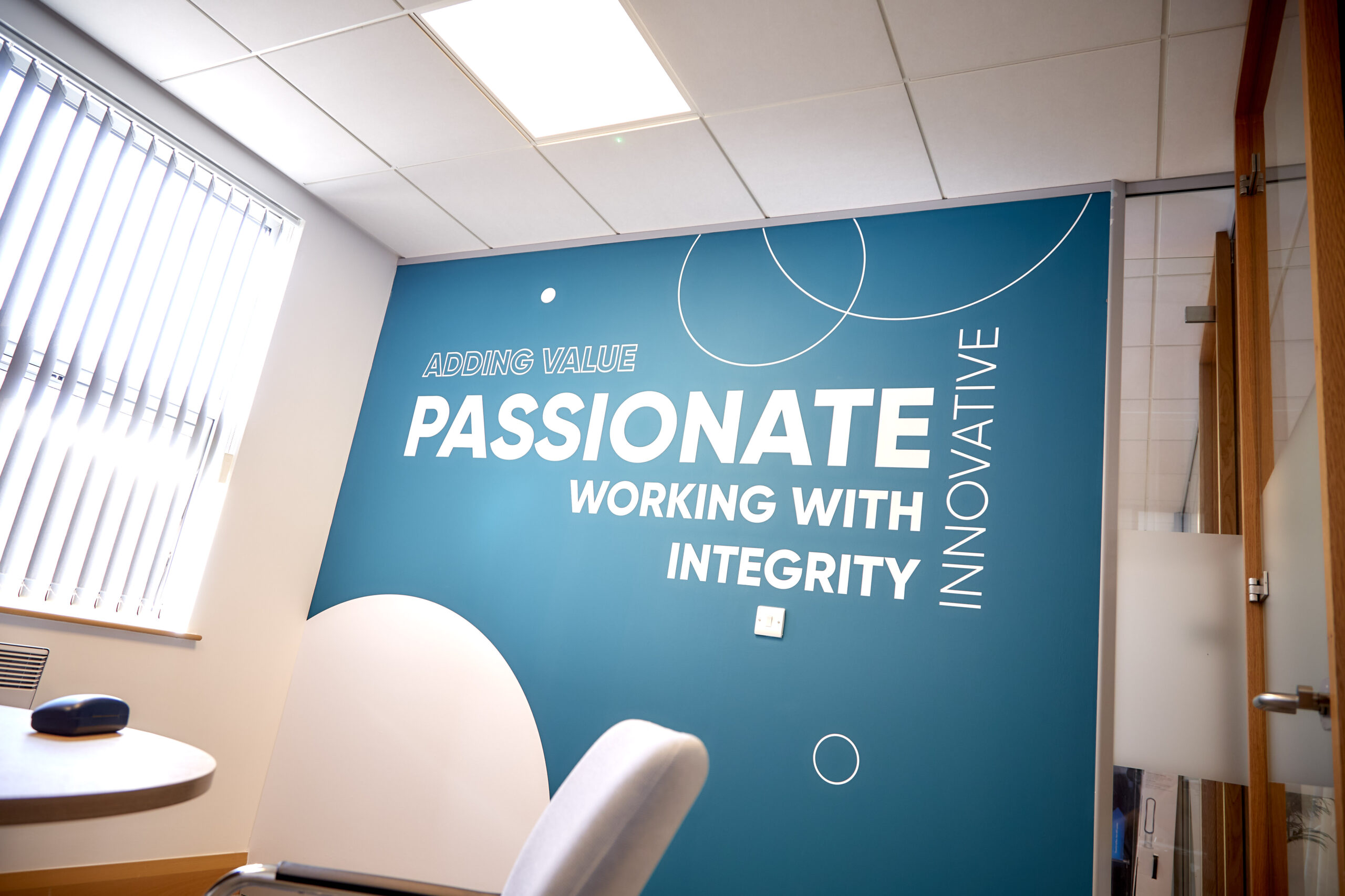 A wall graphic in the Community Ventures office that says 'we are passionate and work with integrity.